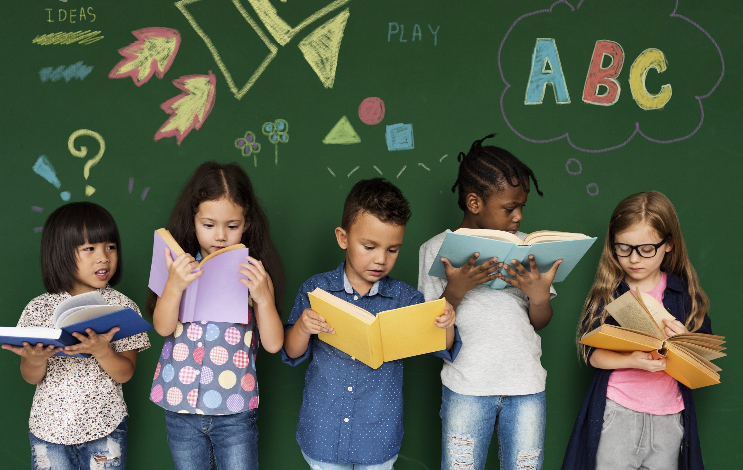 Children reading books at a chalkboard